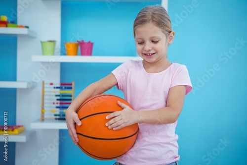 Cute girl holding basket ball 