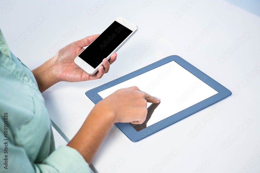 Businesswoman using her digital tablet and her smartphone Businesswoman using her digital tablet and her smartphone