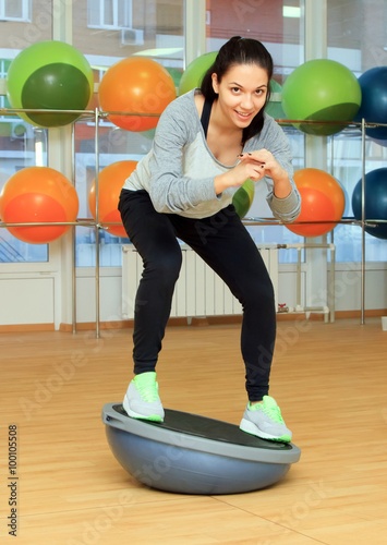 Young woman doing fitness exercise with bosu ball photo