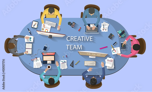 Flat design - business concept - top view of creative team working together around a desk with a desktop, laptop, tablet and other objects , trying to find new and bright ideas for the company.