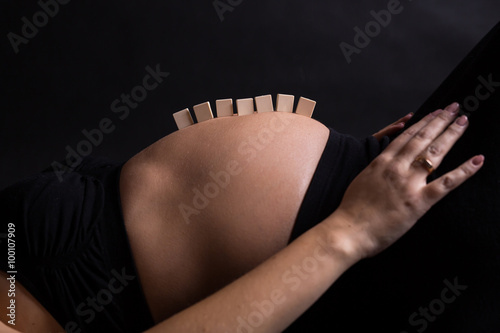 Empty letter boxes on pregnant woman belly photo