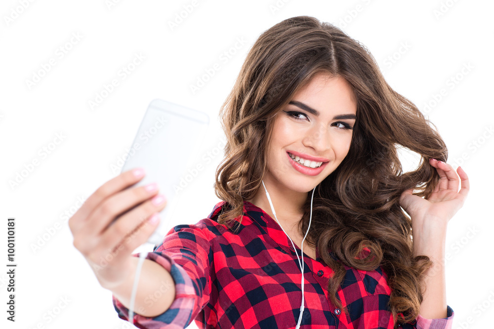 Fototapeta premium Cheerful attractive young woman smiling and taking selfie