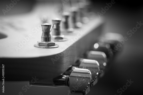 Guitar headstock close-up. Guitar pegs black and white. Retro stylized with shallow depth of field