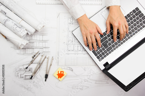 Architect working on blueprint. Architects workplace - architectural project, blueprints, ruler, calculator, laptop and divider compass. Construction concept. Engineering tools photo