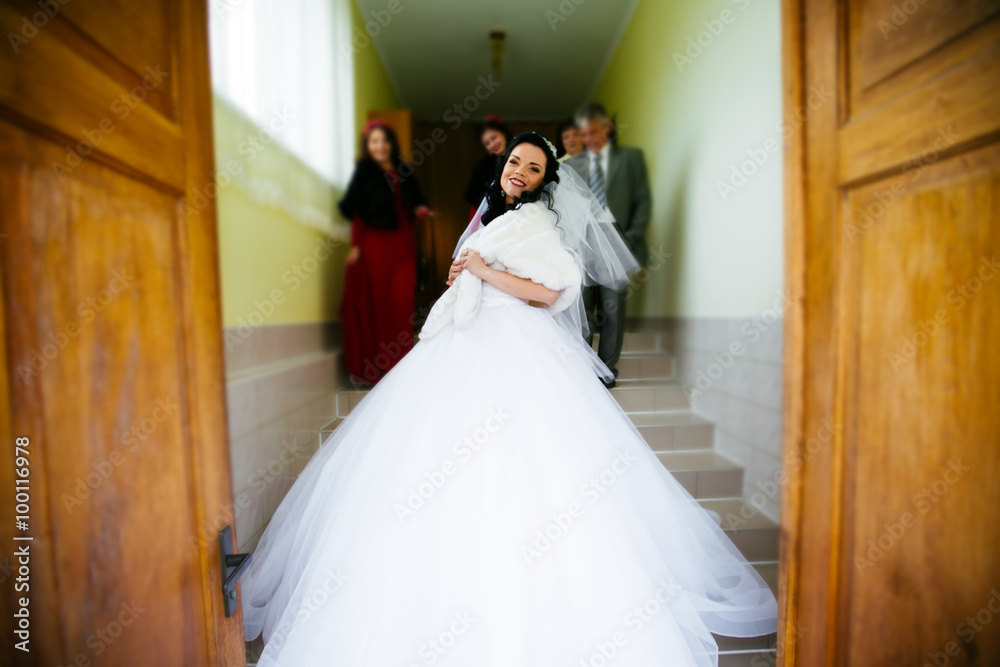 Beautiful charming bride in a luxurious dress looking up. blurre