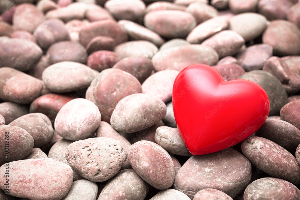 Fototapeta premium Red heart on pebble stones