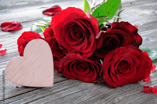 Fototapeta Naklejka Na Ścianę i Meble -  Red roses and heart on wooden background