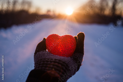 heart in the snow in the rays of the sunsetAbstract heart on hand with snow in the rays of the sunset photo