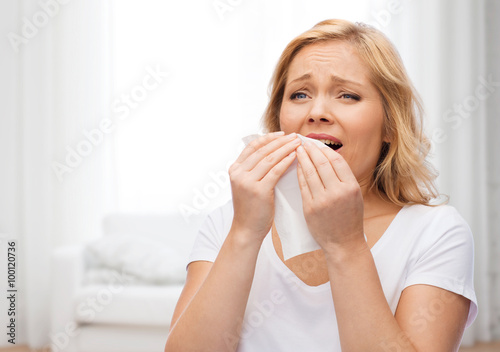 Φωτογραφία unhappy woman with paper napkin sneezing