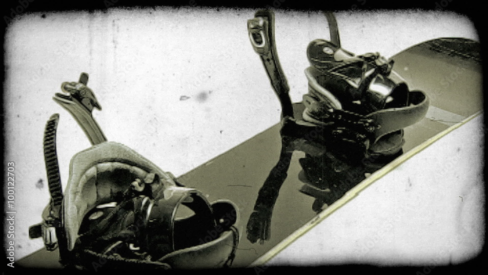 Close up of snow board moving from top view to side. Vintage stylized video clip.
