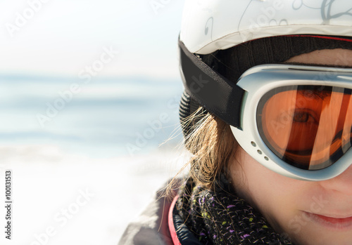 Young woman skier at winter ski resort in mountains, face close up