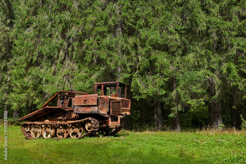 abandoned skidder against the backdrop of an ancient  forest