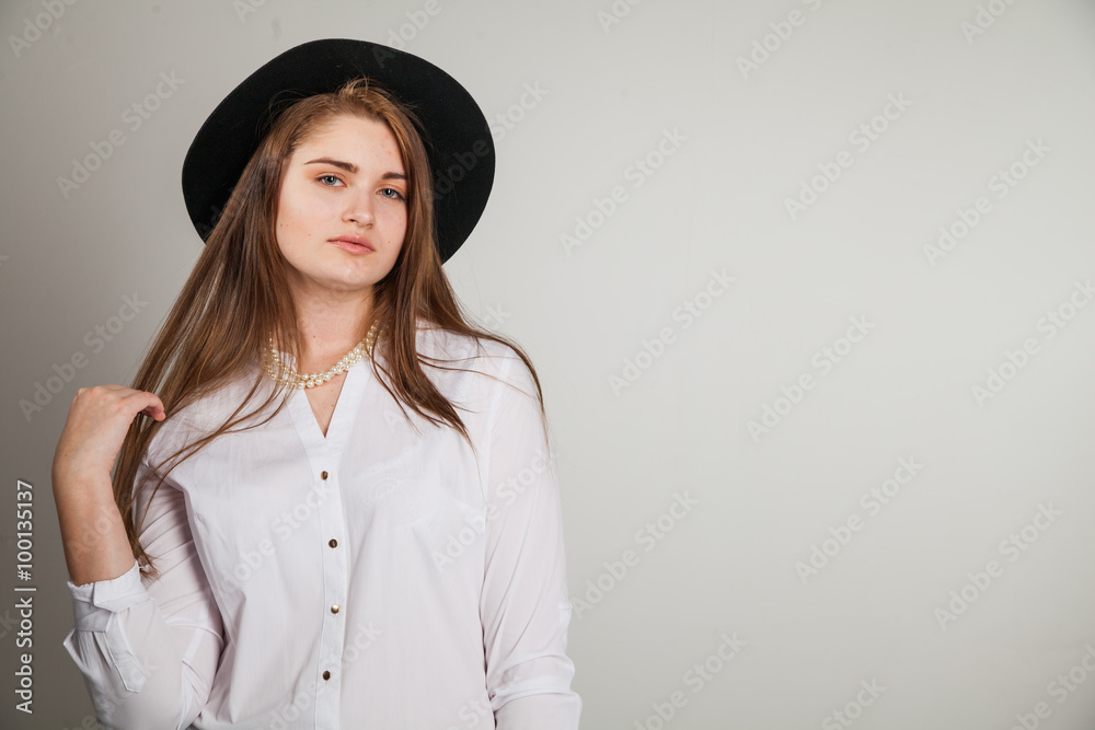 Awesome Caucasian attractive shy sexy female model with brunette hair posing on table in studio, wearing formal suit and hat, isolated on white background Awesome Caucasian attractive shy sexy female model with brunette hair posing on table in studio, wearing formal suit and hat, isolated on white background