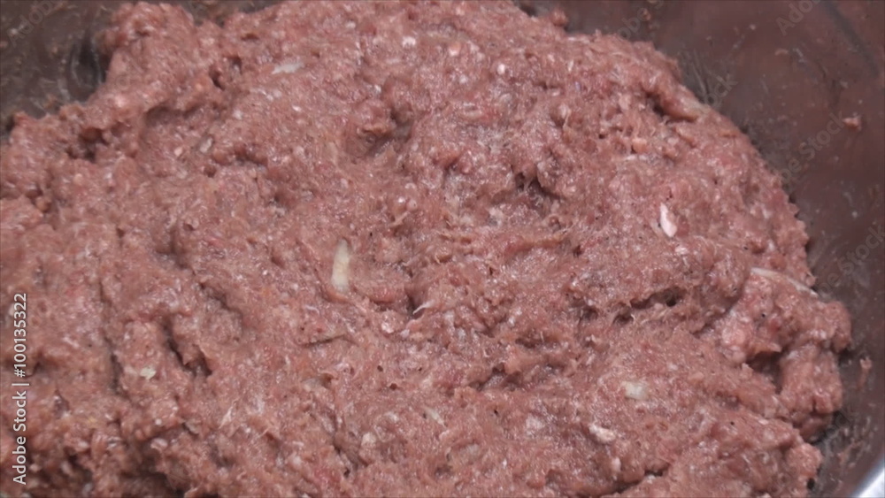Zoom in of seasoned ground meat in the stainless steal metal bowl. (Preparing meat for meatballs) Zoom in of seasoned ground meat in the stainless steal metal bowl. (Preparing meat for meatballs)