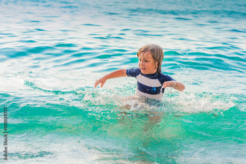 Adorable kid having fun on summer vacation, playing in the sea, image taken in Tropea, Calabria, Italy