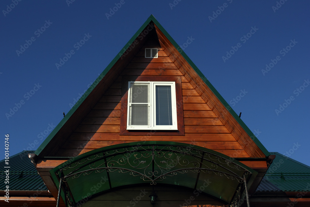 Green metal roof  and white attic window