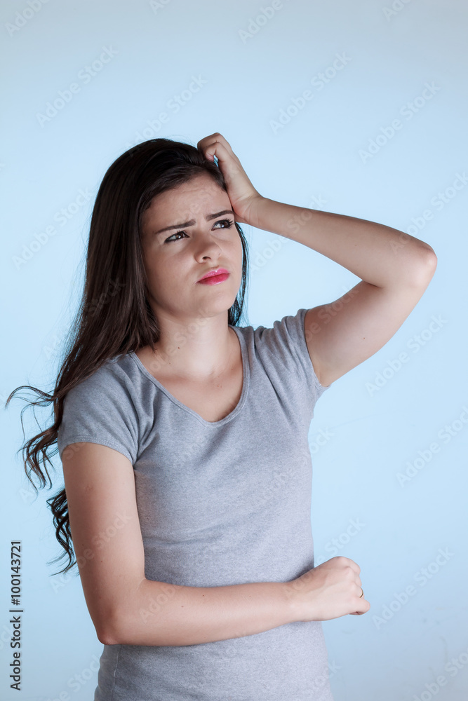 Young woman with doubt expression. Woman scratching her head iso Young woman with doubt expression. Woman scratching her head iso
