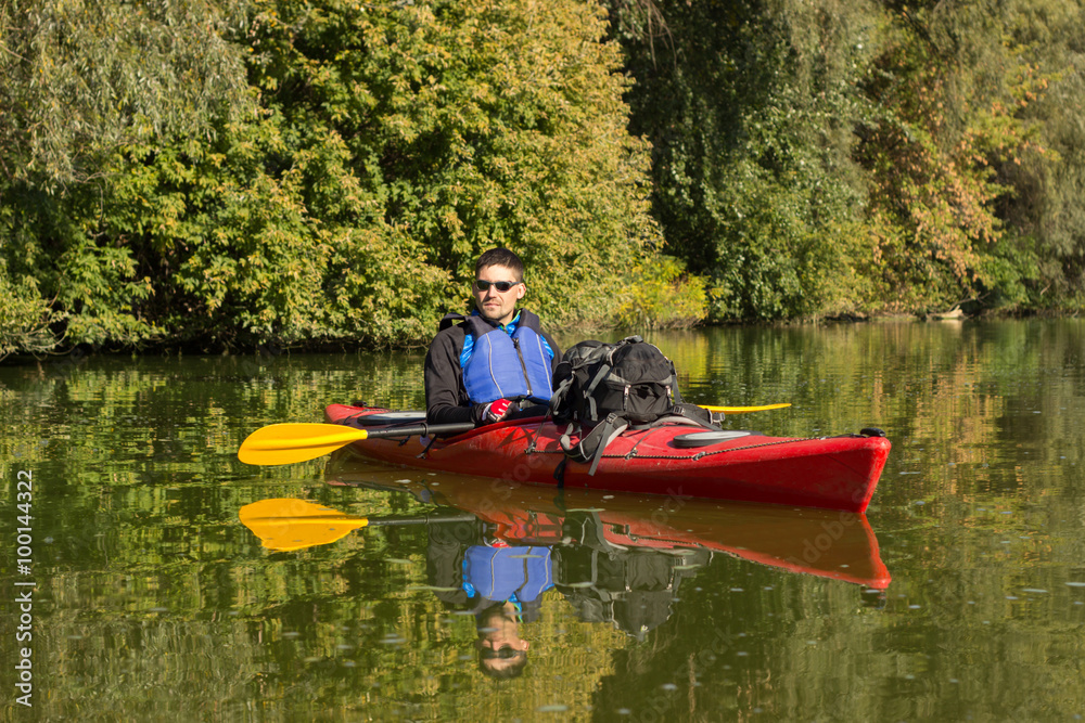 The man is kayaking on the river.