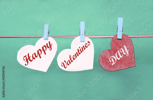 white and Red hearts with clothespins hanging on clothesline on color background. date, love Valentines Day concept