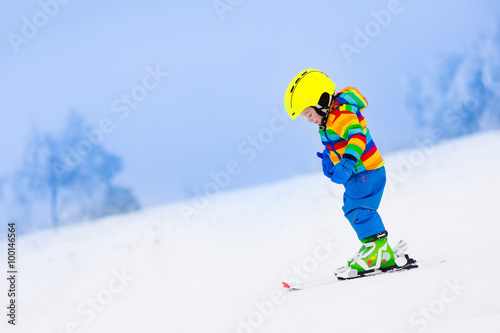 Little child skiing in the mountains in winter