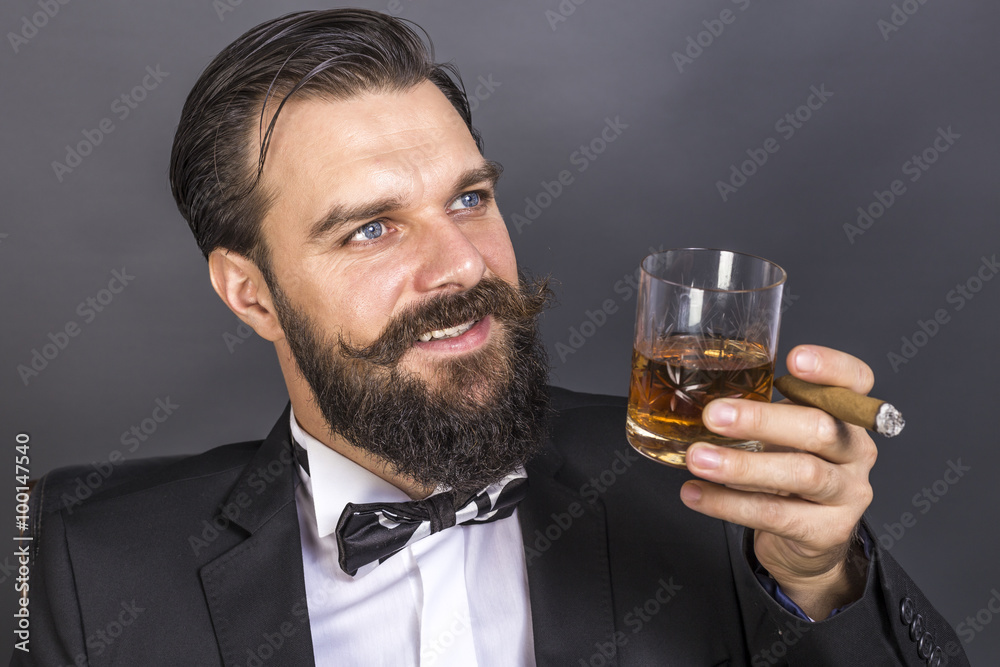 Portrait of a happy young man with retro look sitting in an armc