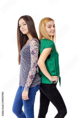 Closeup portrait of two teenage girls standing back to back