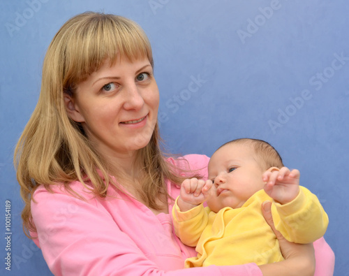 The happy young woman with the baby on a blue background