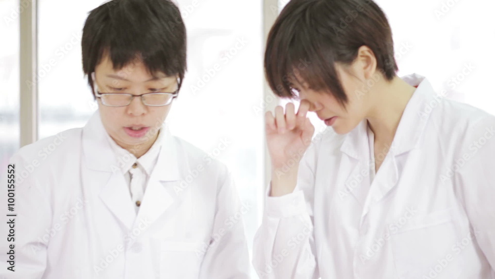 Asian scientists in lab discussing results Asian scientists in lab discussing results