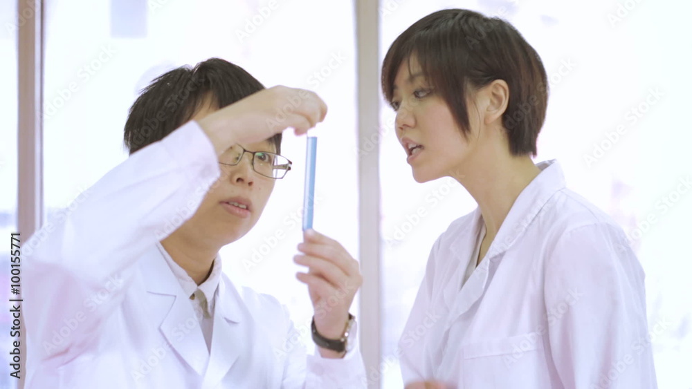 Asian scientists in lab doing experiments Asian scientists in lab doing experiments