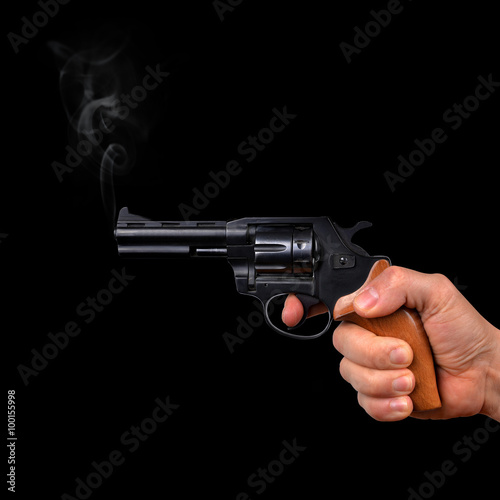Hand holding gun isolated on black background