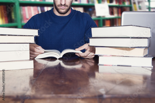 uomo legge libri in biblioteca photo