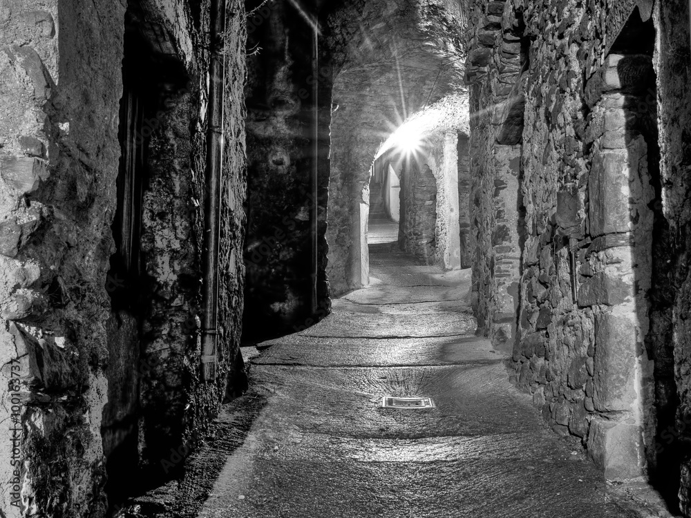 Mediaeval village alley, alleyway with light at end of tunnel Mediaeval village alley, alleyway with light at end of tunnel