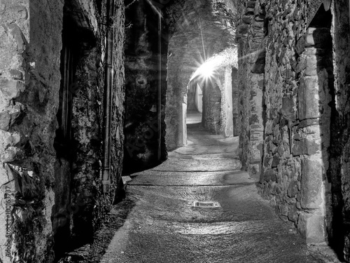 Mediaeval village alley, alleyway with light at end of tunnel