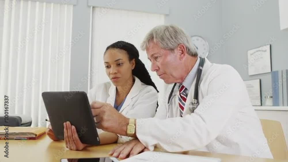 Successfull doctors working on a tablet in the office Successfull doctors working on a tablet in the office