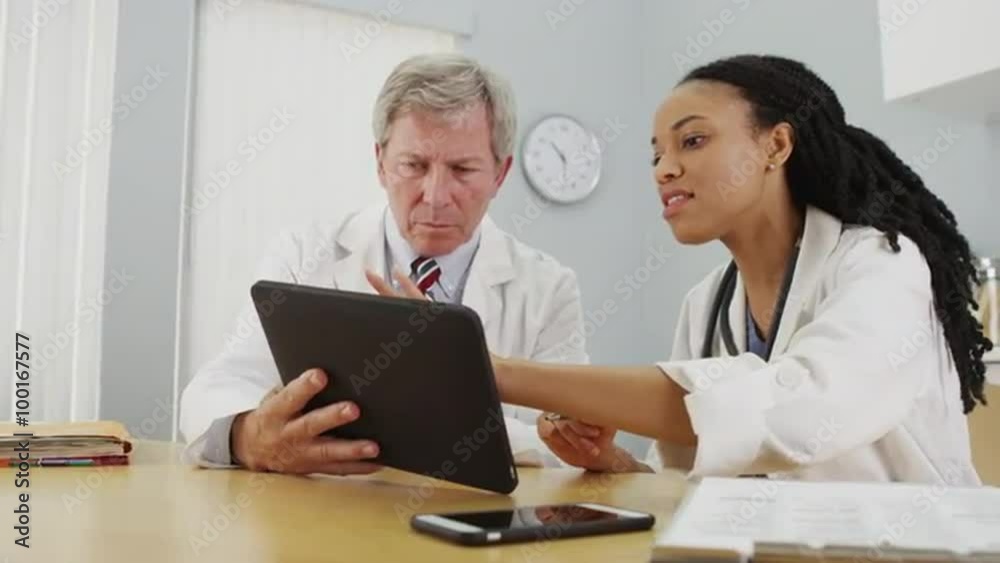 Hardworking doctors reviewing patient's file Hardworking doctors reviewing patient's file