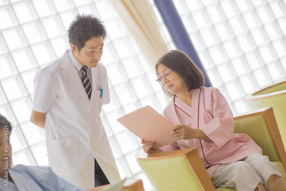 病院内の男性医師と女性患者・健康診断/検査