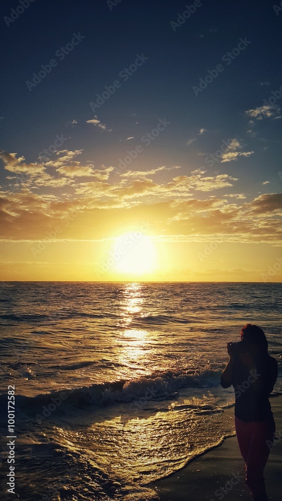 Young woman capture beautiful sea sunrise