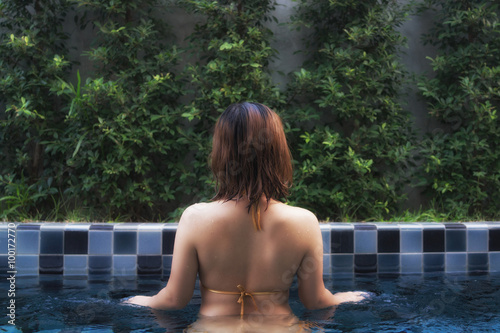 Asian girl in blue private pool in the garden