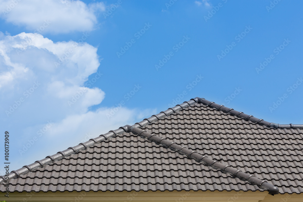 black tile roof of house with blue sky and cloud background black tile roof of house with blue sky and cloud background