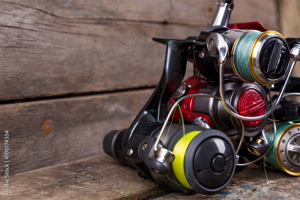 different fishing reels with line on wooden background different fishing reels with line on wooden background