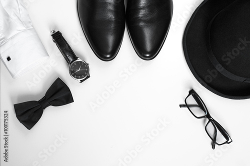 Men's accessories men's shoes, watches, glasses, bow tie, sleeve shirt and hat/Black and white minimalistic composition on a white background. Classic men's accessories. Top view
