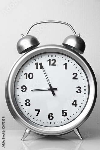 The big clock on a white background/The clock looks like an alarm clock. Black and white photography