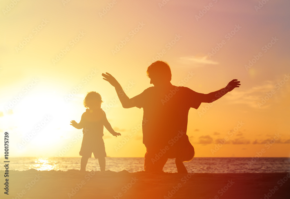 Father and little daughter playing silhouettes at sunset