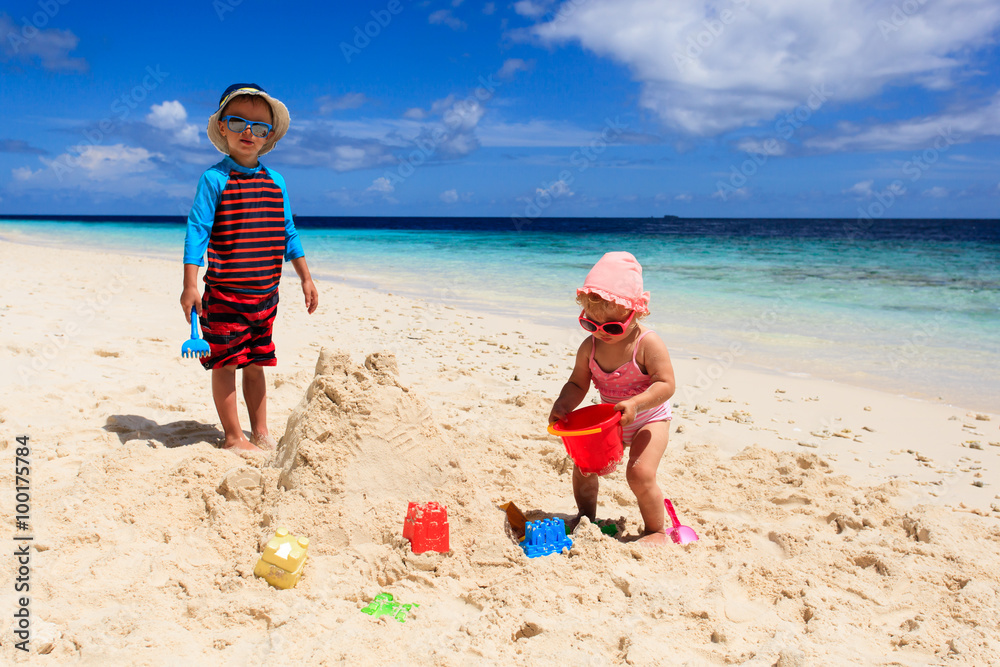 little boy and girl building sandcastle on beach little boy and girl building sandcastle on beach