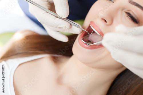 Skilled young dentist is treating female health