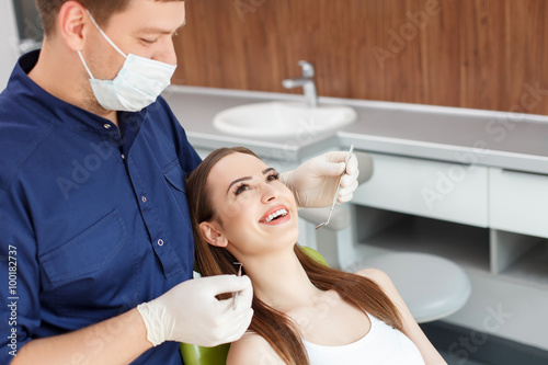 Cheerful young woman is visiting a dental doctor