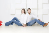 Portrait of a man and woman. Portrait of husband and wife in shirts against a white wall. 