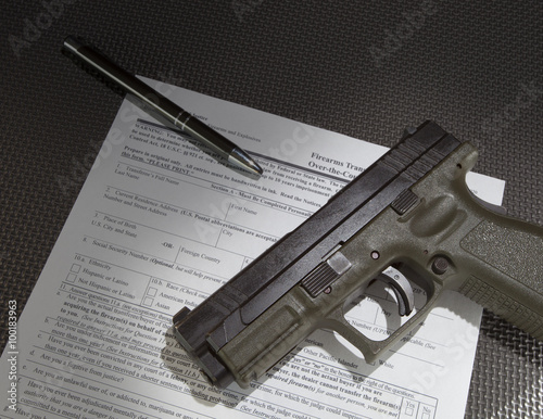Handgun and the paperwork to get a background check before taking ownership photo