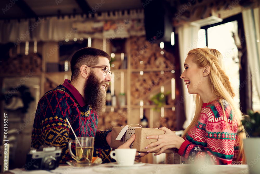Lovely hipster couple enjoying sharing presents. Shallow depth of field.