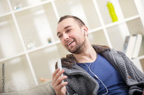 Young attractive having fun alone holding mobile phone as microphone
